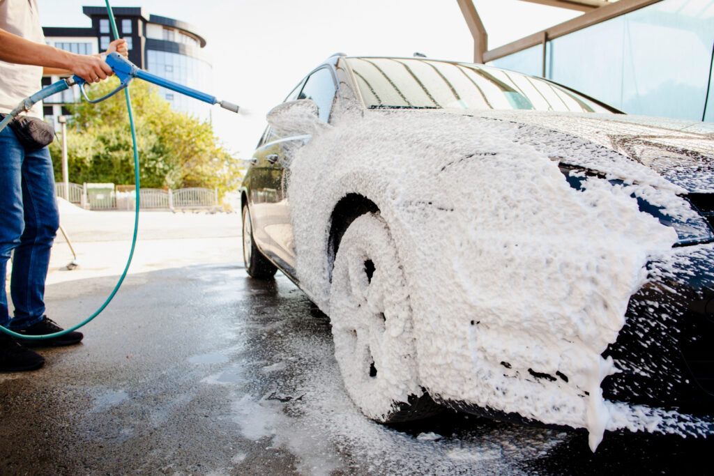 Car being washed with foam and water to compare washing methods