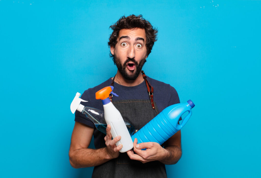Man holding household cleaning bottles