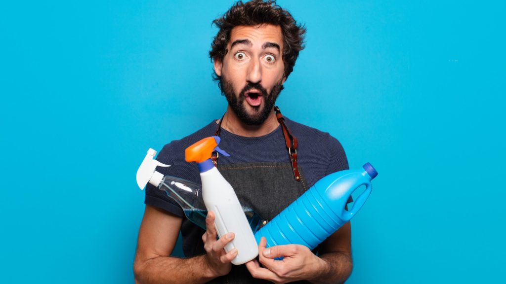 Man holding household cleaning bottles