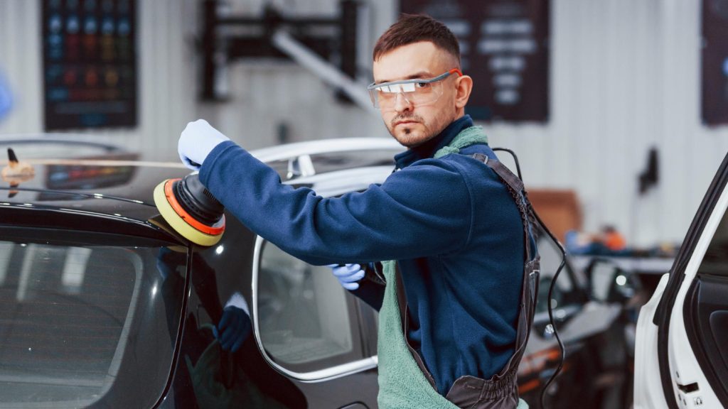 Worker applying protective car coating