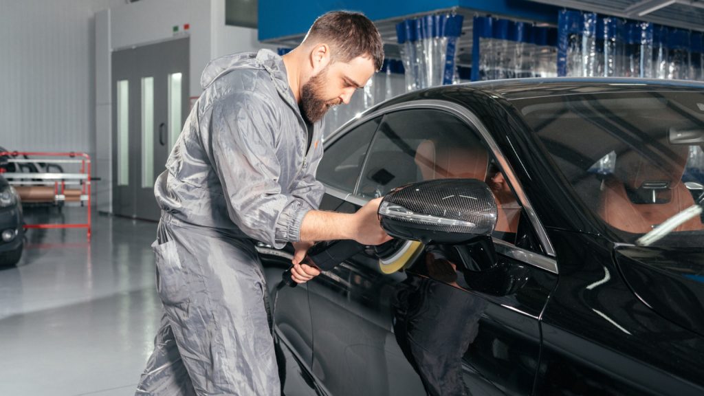 Mechanic inspecting car for damage